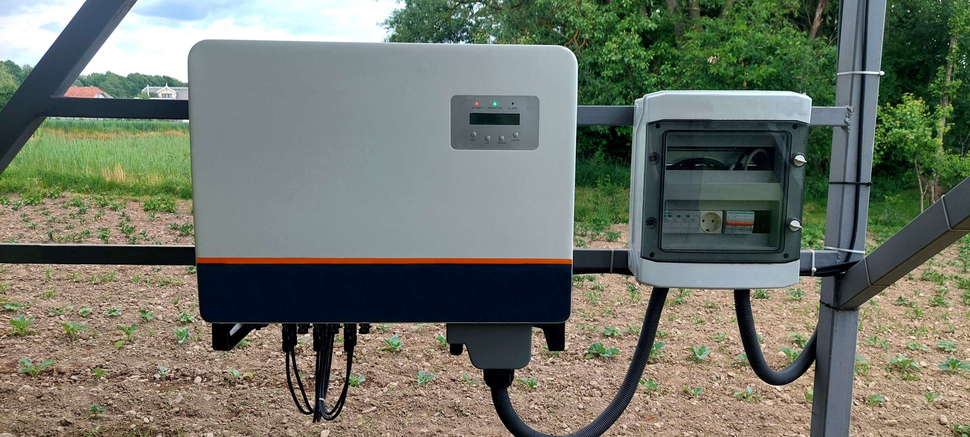 Close-up of a Tesla Powerwall and electrical panel outdoors.
